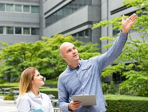 Businessman and businesswoman looking upward outdoor